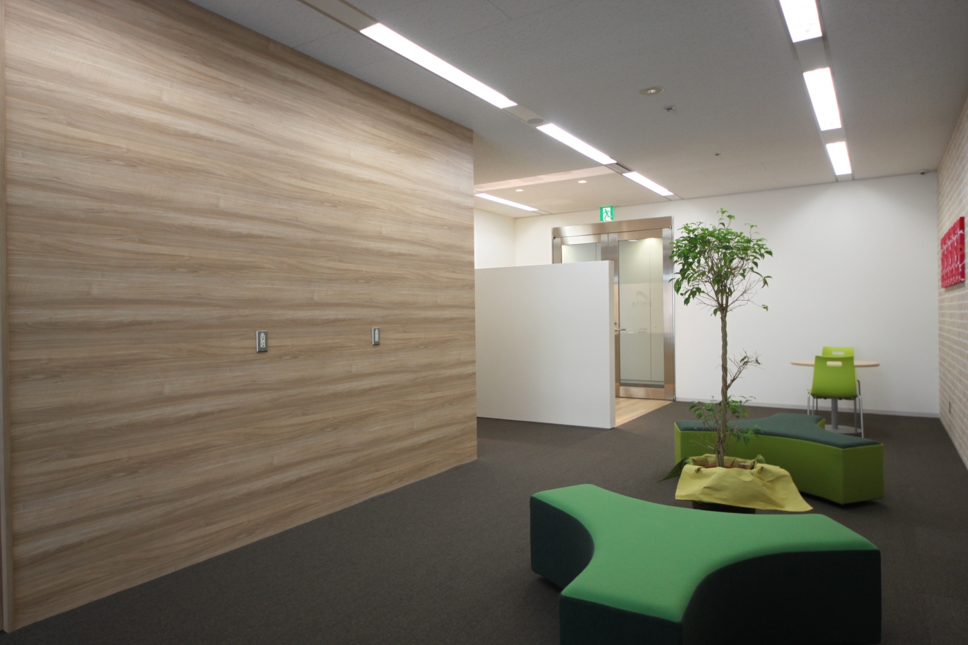 オフィスデザイン実績～こて仕上げの壁と木目タイルがぬくもりを与えるレセプションオフィス