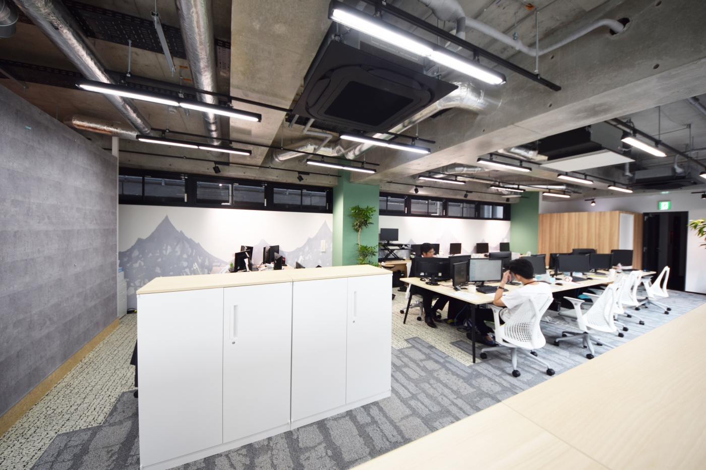 オフィスデザイン実績～ガラスに囲われた会議室が特徴的。スケルトン天井で開放感溢れるオフィス